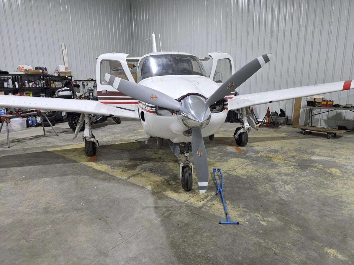Front view of the Piper PA-28R-201T Turbo Arrow III in a hangar with the doors open.