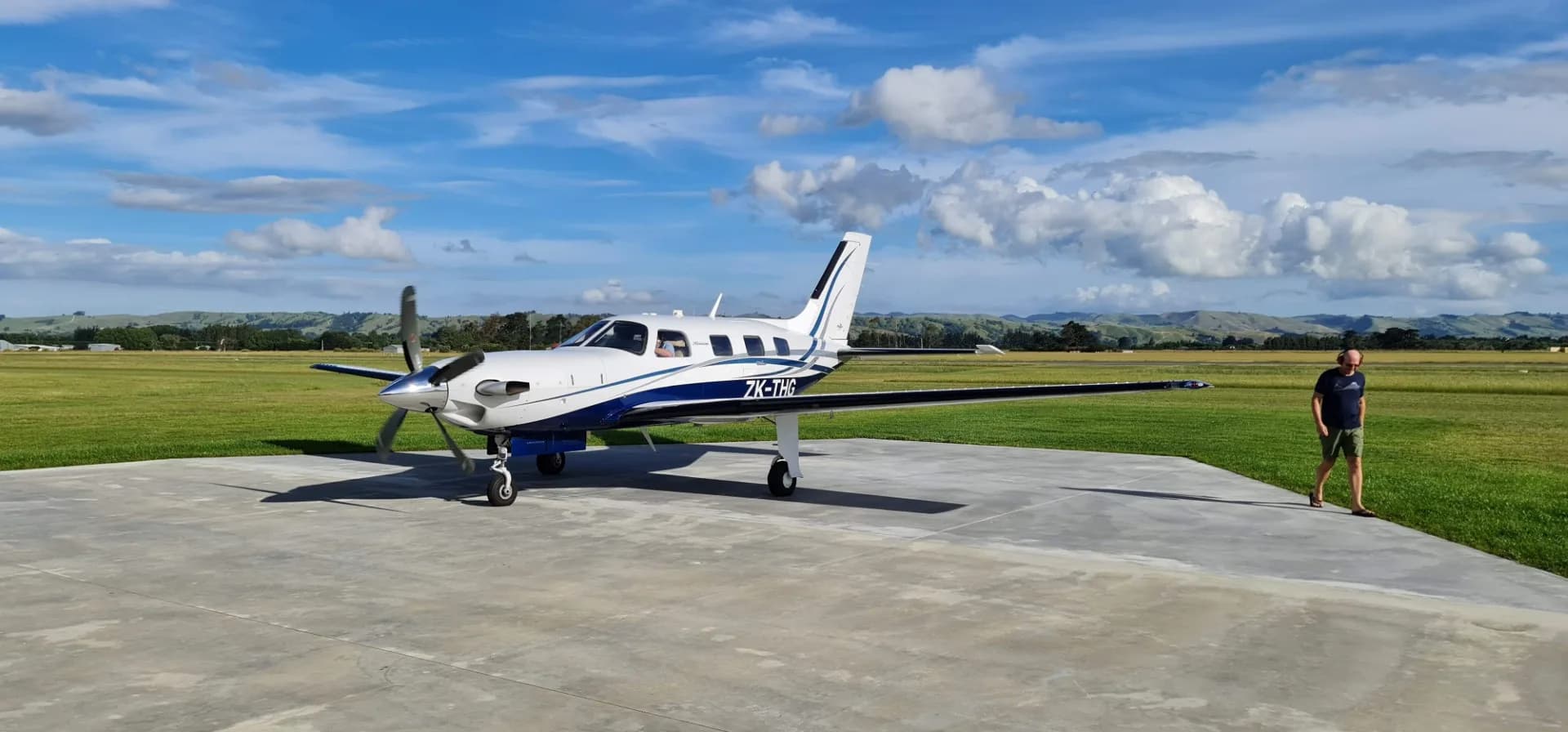 Piper PA-46 Malibu Mirage on the tarmac with a blue and white paint scheme.