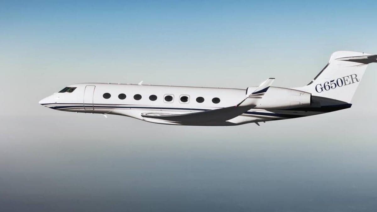 A Gulfstream G650ER in flight against a blue sky.
