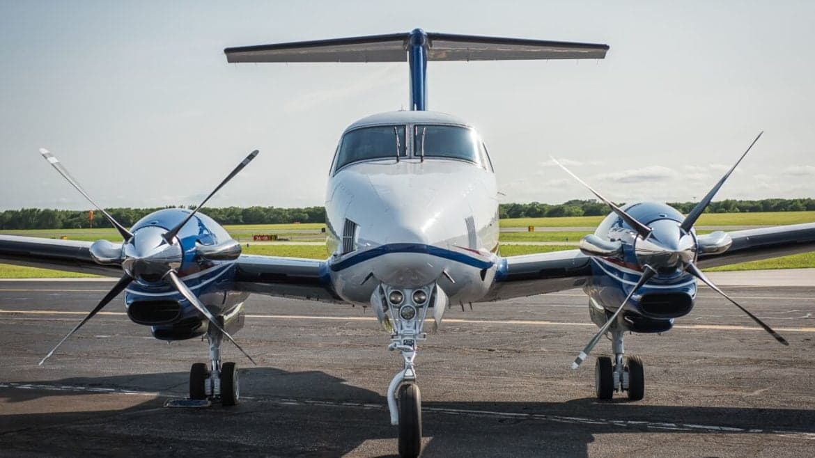 Front view of a twin-engine turboprop aircraft on the tarmac.