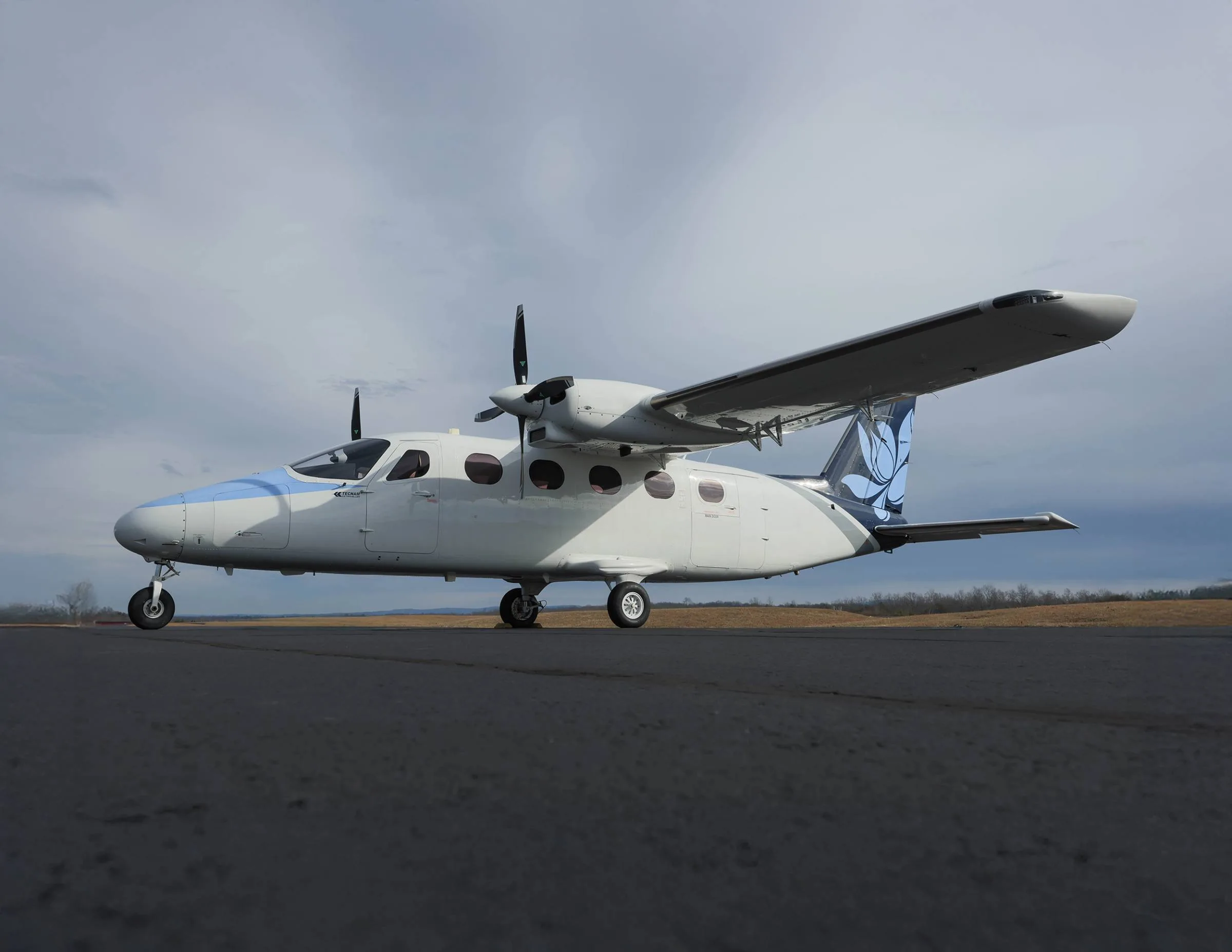 Side view of a white and blue aircraft on the tarmac.