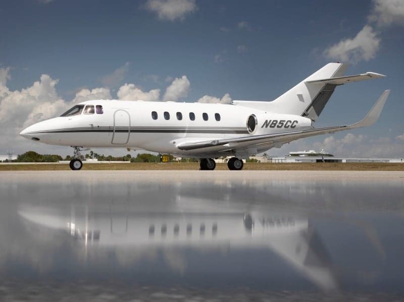 Side view of a white jet with registration N85CC on the tarmac.