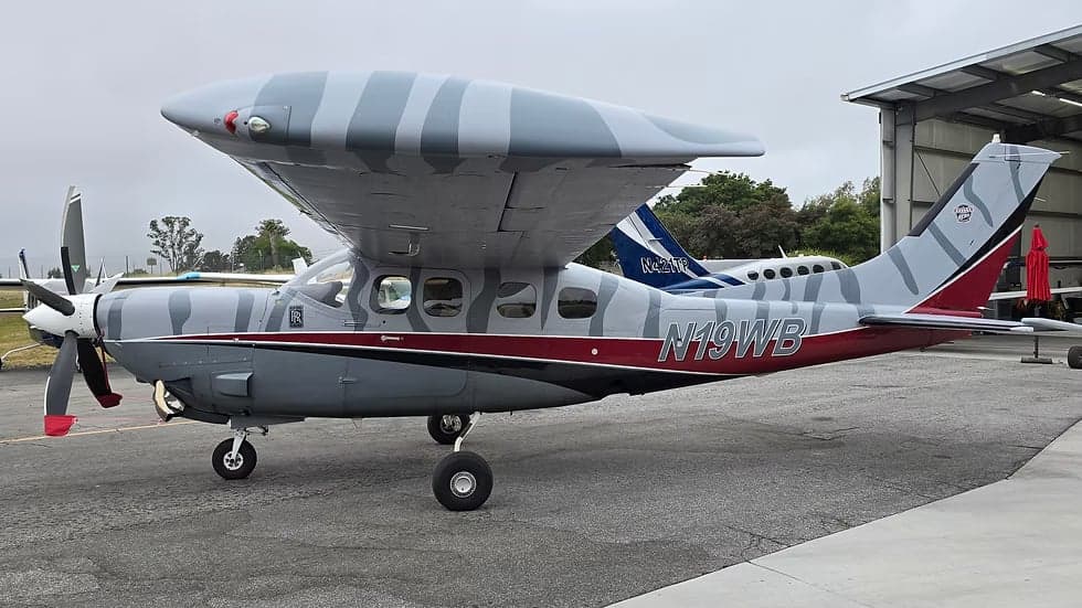 Side view of the N19WB Cessna Caravan with a gray and white striped paint scheme on the wings and tail.