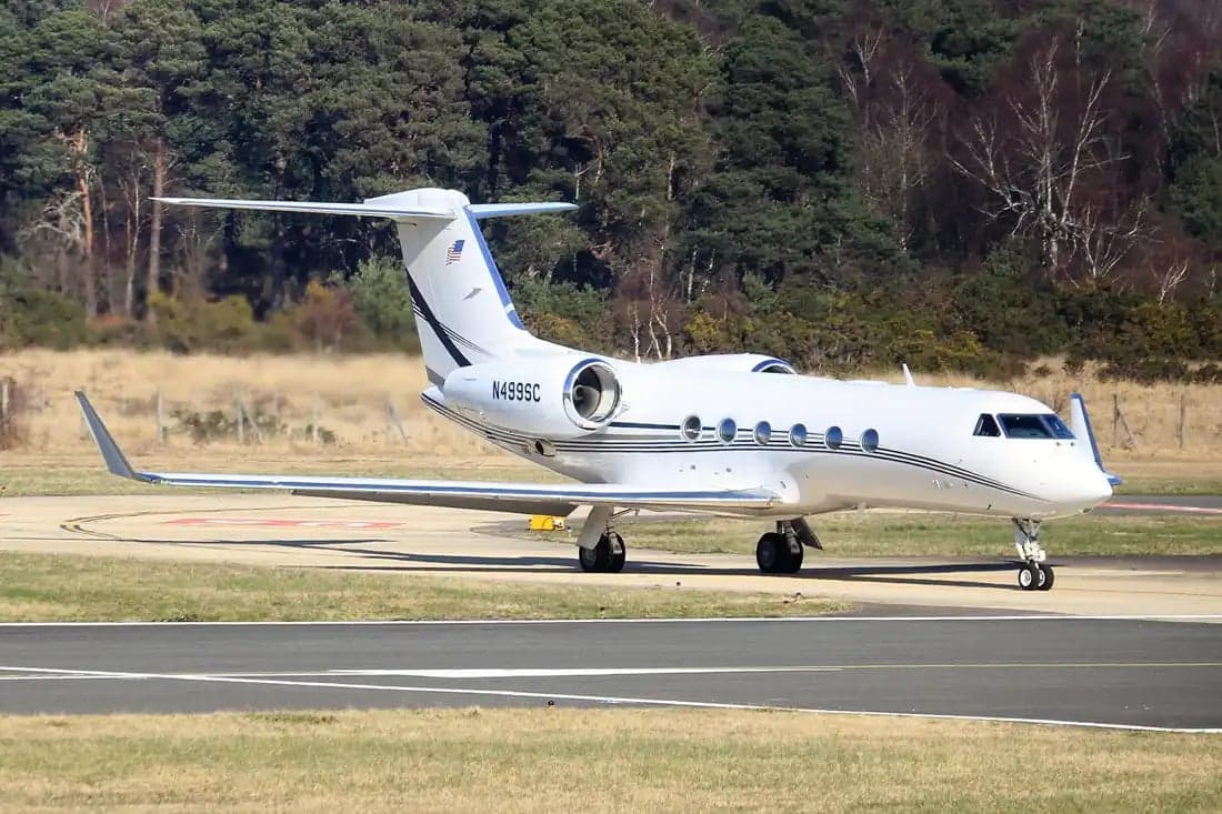 A white Gulfstream G550 aircraft with registration N499SC is parked on the tarmac.