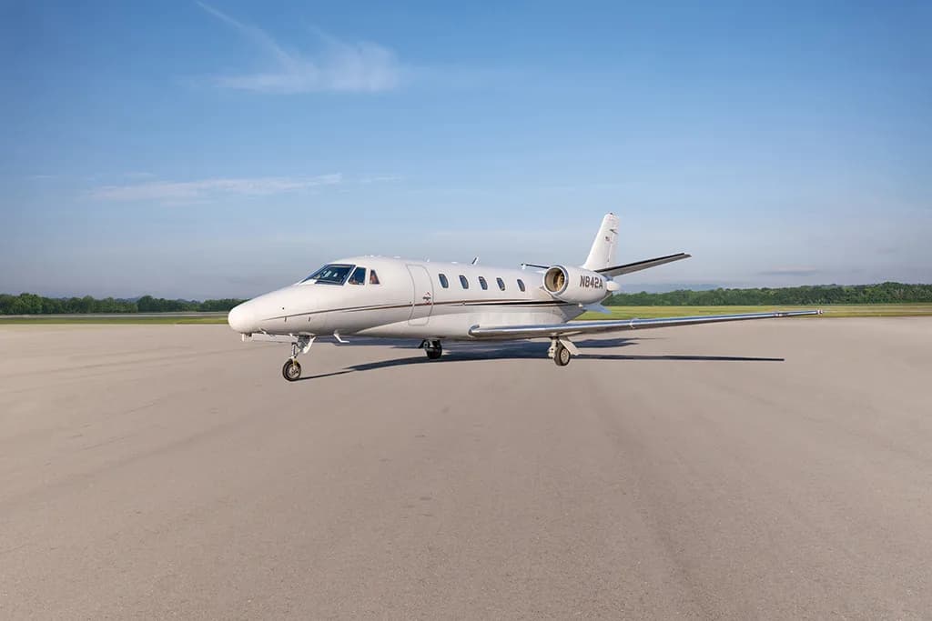 A white Cessna Citation business jet, registration N842A, parked on a tarmac under a clear blue sky.
