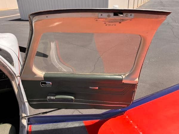 Open door of the aircraft showing the wing and door panel.