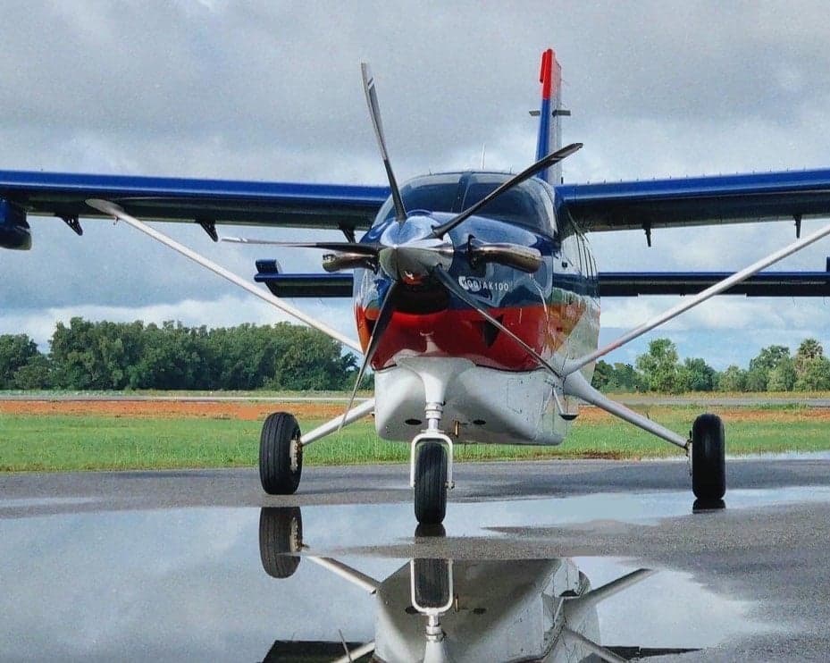 Front view of a Kodiak 100 on the tarmac with a reflection in the water.