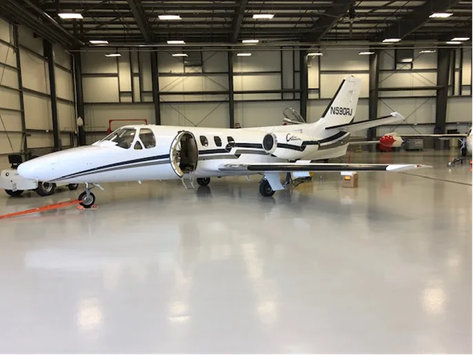 Cessna Citation N590RJ parked in a hangar with the door open.