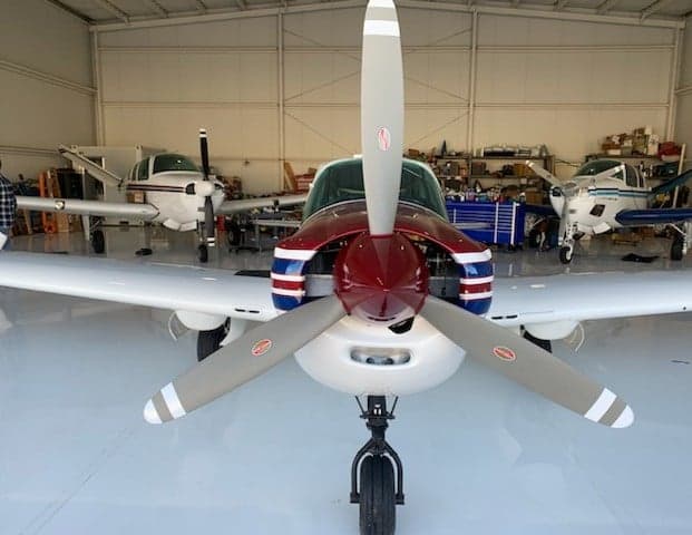 Front view of N4205B aircraft in a hangar with other aircraft in the background.