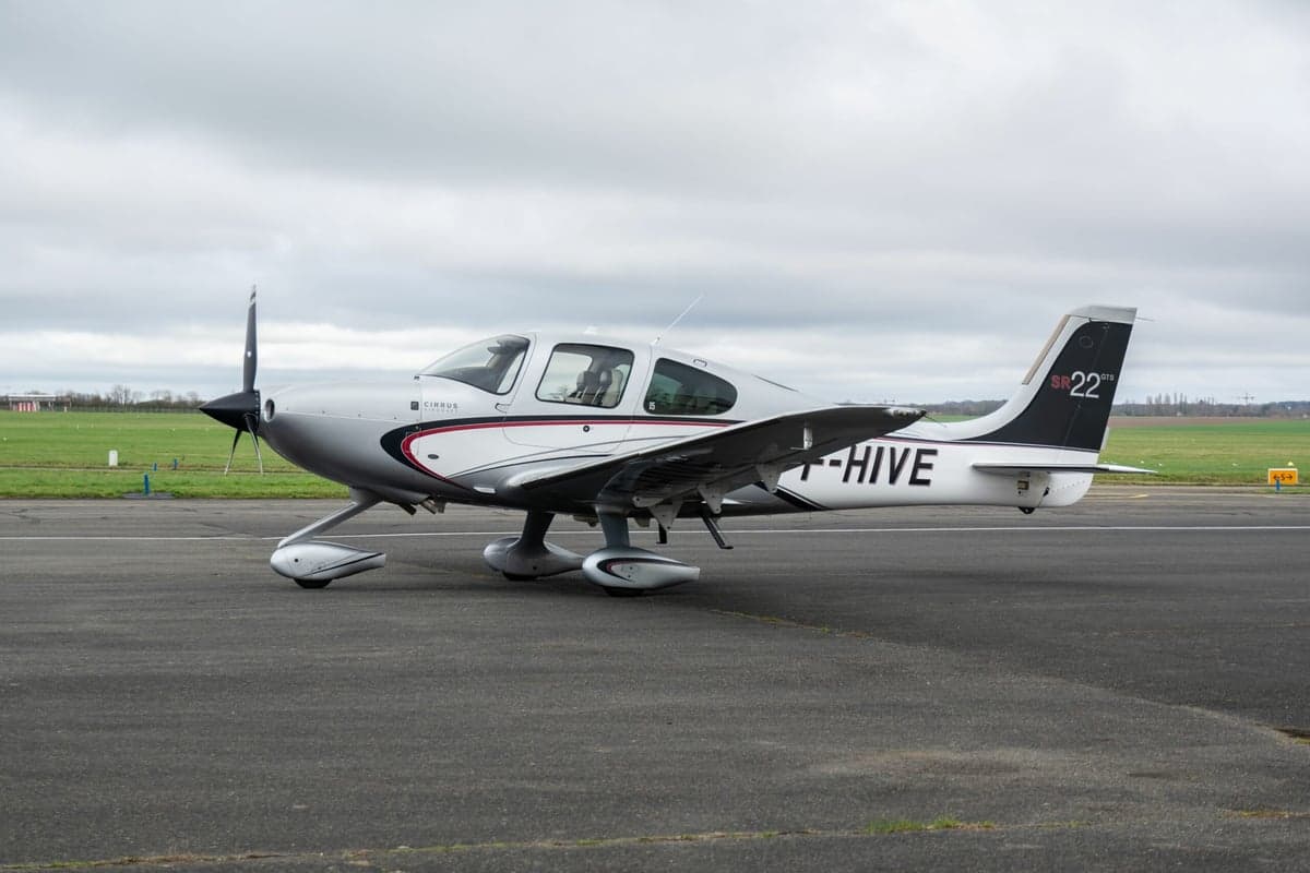 A Cirrus SR22 aircraft with registration F-HIVE parked on the tarmac.