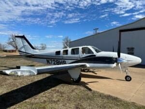 N728HS aircraft parked outside a hangar on a sunny day.