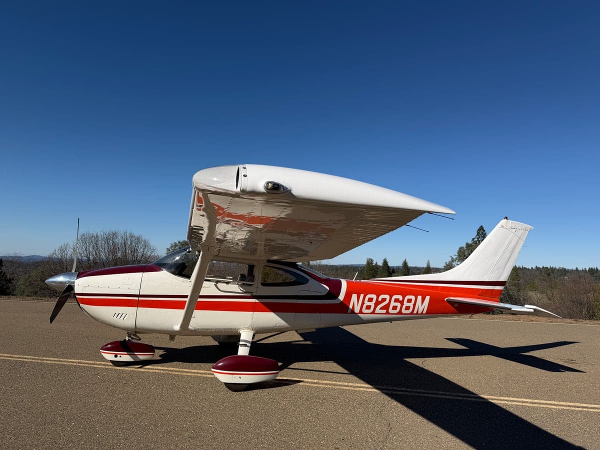 The N8268M aircraft parked on a runway, showcasing its white and red paint scheme.
