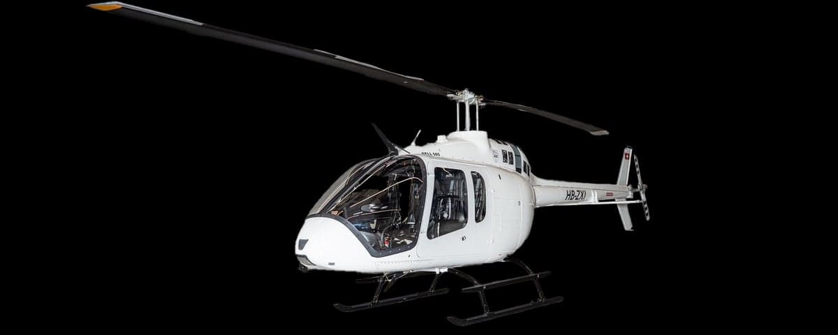 A white Bell 505 helicopter on a black background.