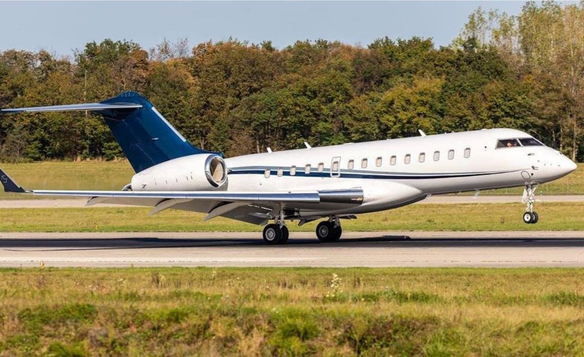 A white and blue Bombardier Global Express aircraft on the runway.