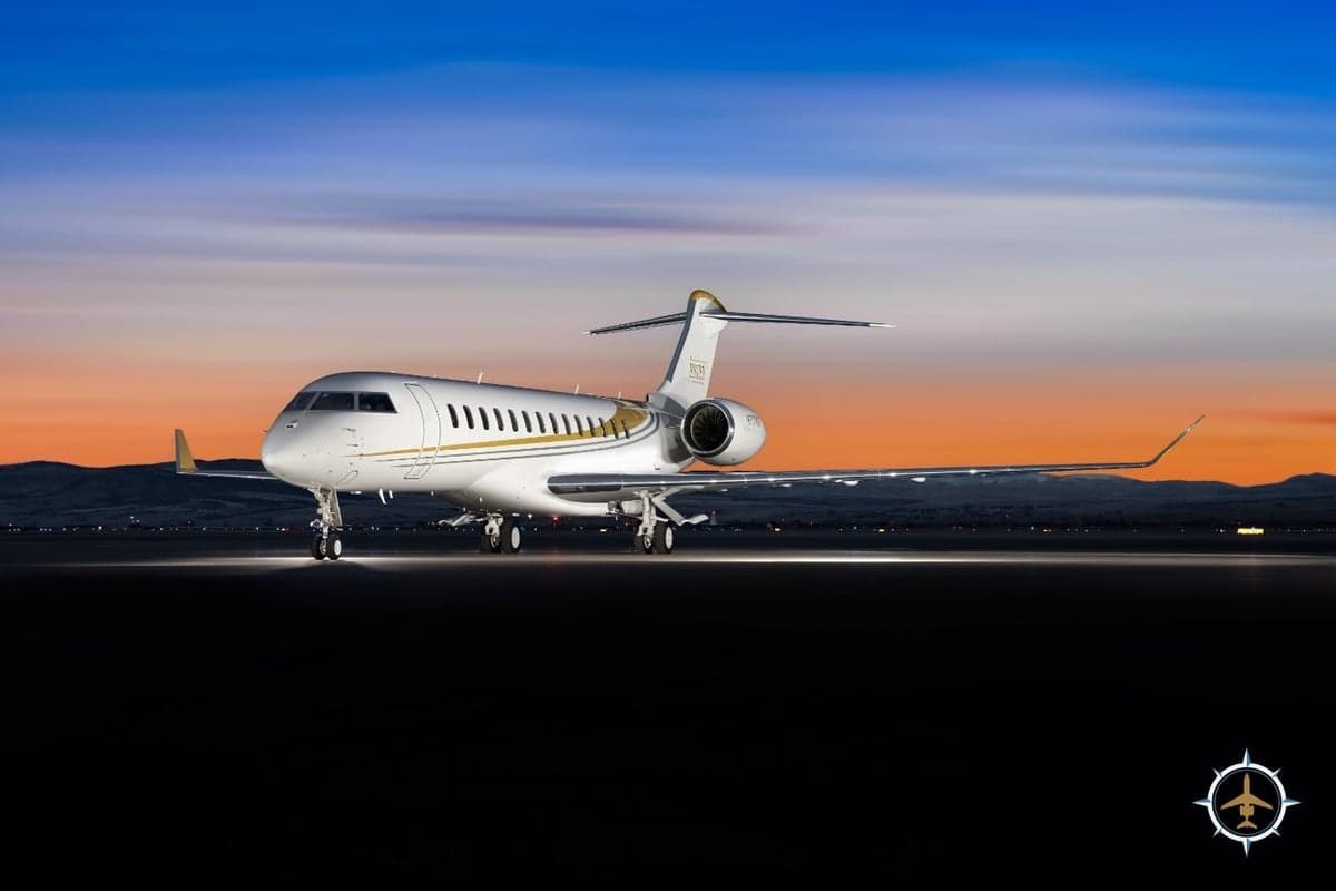 A Bombardier Global Express aircraft sits on the tarmac at dusk.