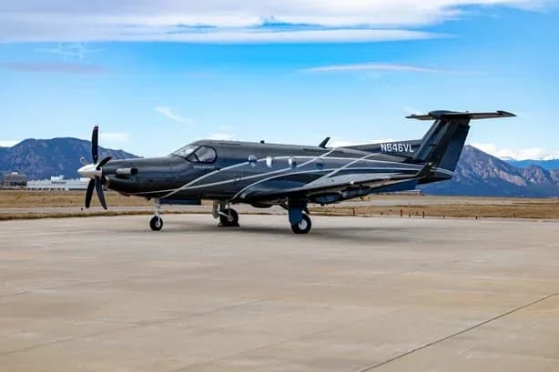 Pilatus PC-12 aircraft N646VL is parked on the tarmac with mountains in the background.