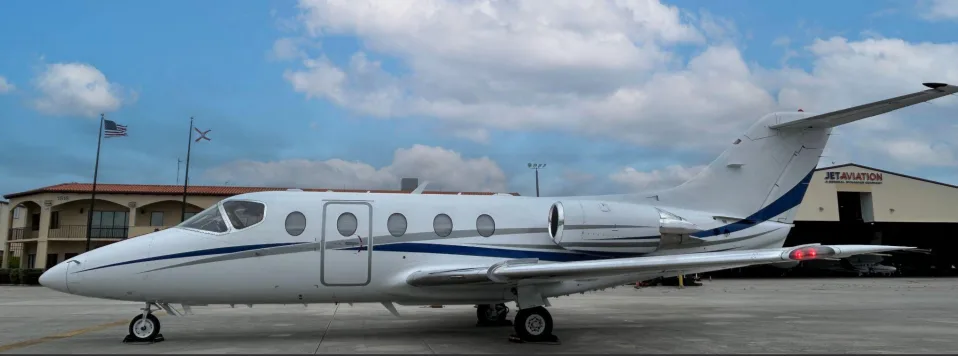 Side view of a white and blue jet aircraft on the tarmac.