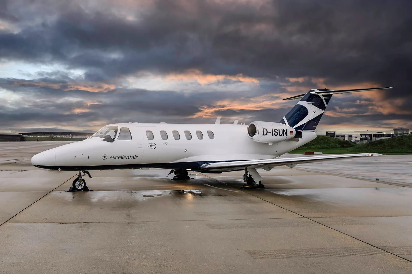 A Cessna Citation CJ2 aircraft with registration D-ISUN parked on the tarmac at dusk.