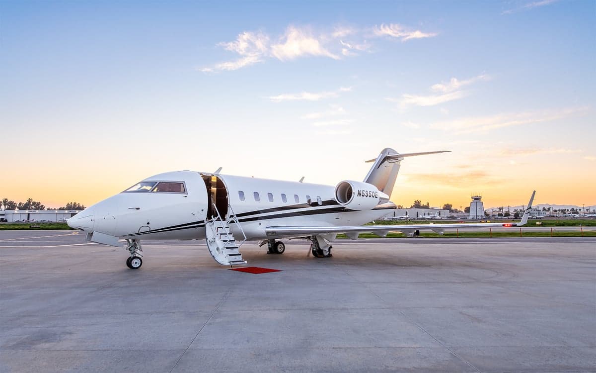 Challenger aircraft on the tarmac with the door open and stairs down.