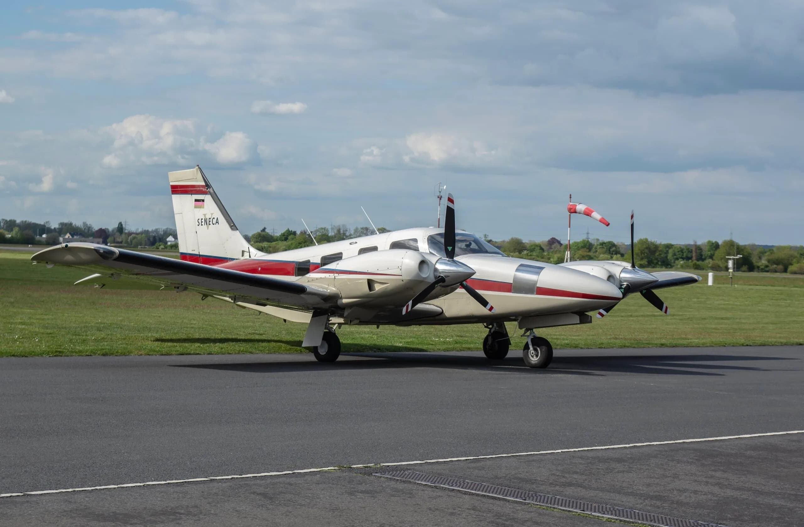 A Piper Seneca aircraft is parked on the tarmac.