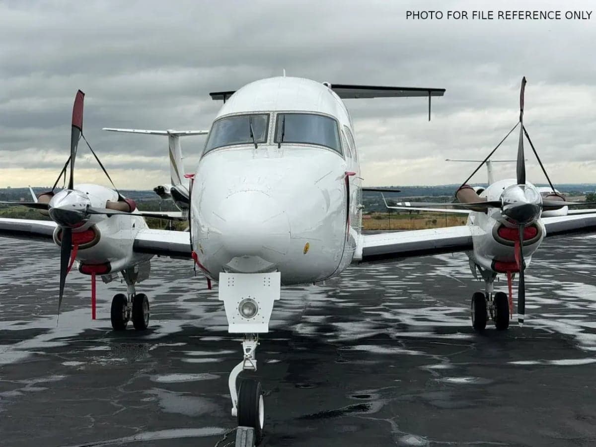 Front view of a white Beechcraft 1900 on the tarmac.