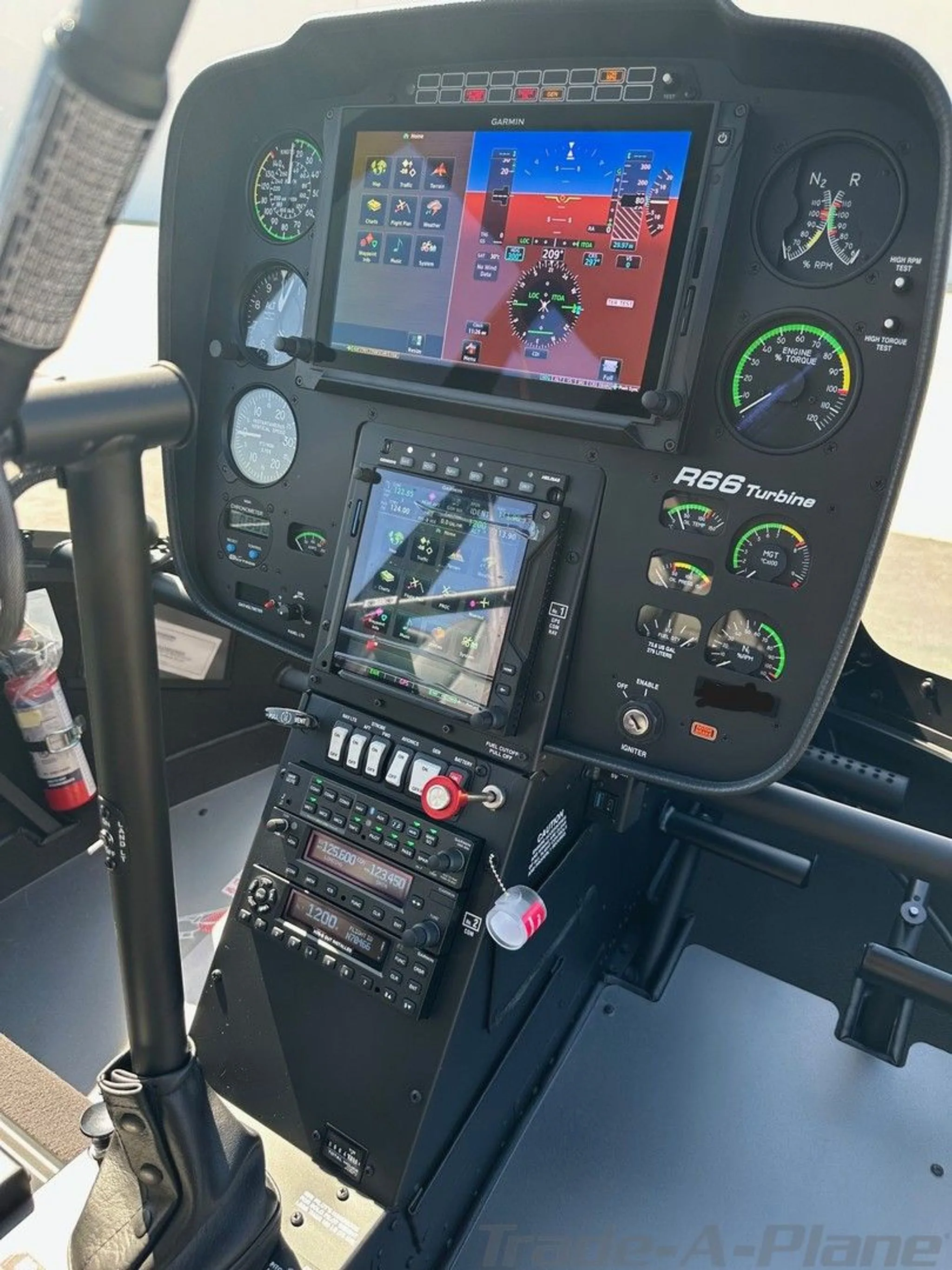 The cockpit of a Robinson R66 Turbine helicopter features a modern instrument panel with multiple digital displays and analog gauges.