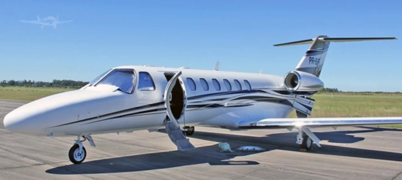 A Cessna Citation CJ3+ with an open door on the tarmac.