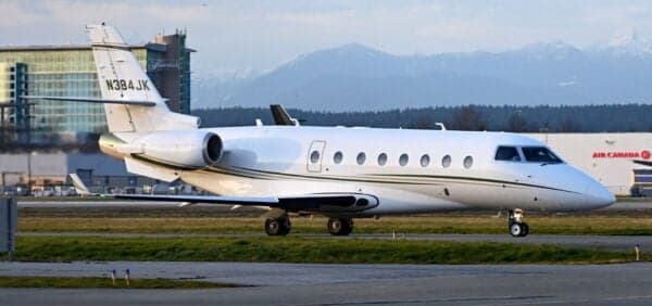 A white aircraft with tail number N384JK is parked on the tarmac.