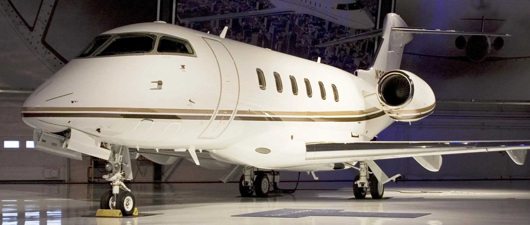 Side view of a white and gold jet in a hangar.