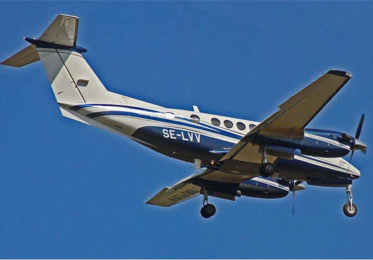 King Air aircraft in flight with blue and white paint scheme.