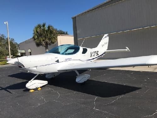 A white Sport Cruiser aircraft with tail number N137SC parked on the tarmac.