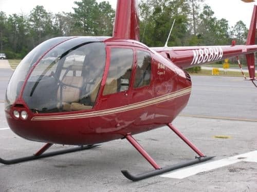 A red Robinson R44 helicopter with tail number N888HA is parked on the tarmac.
