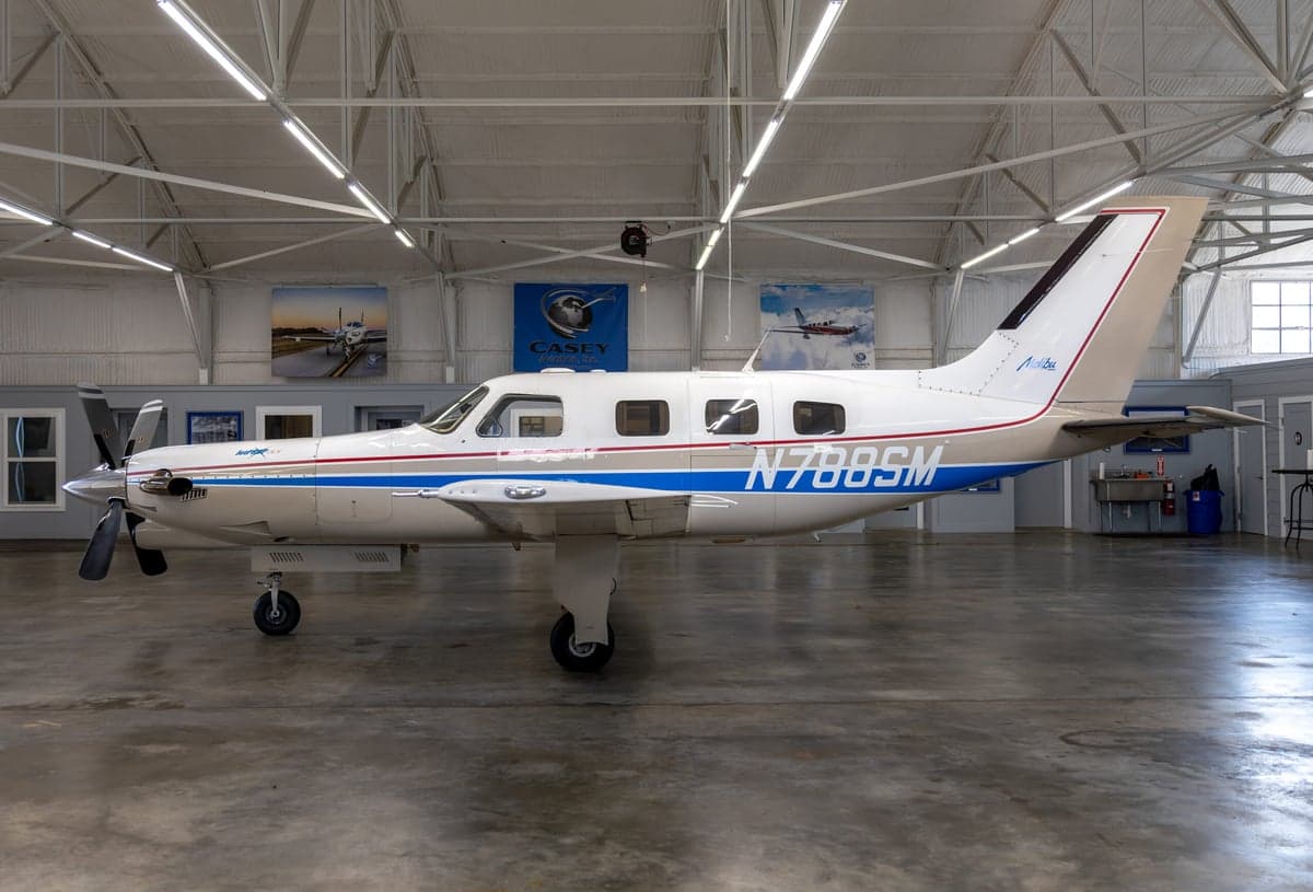 A side view of the N788SM Malibu aircraft in a hangar.