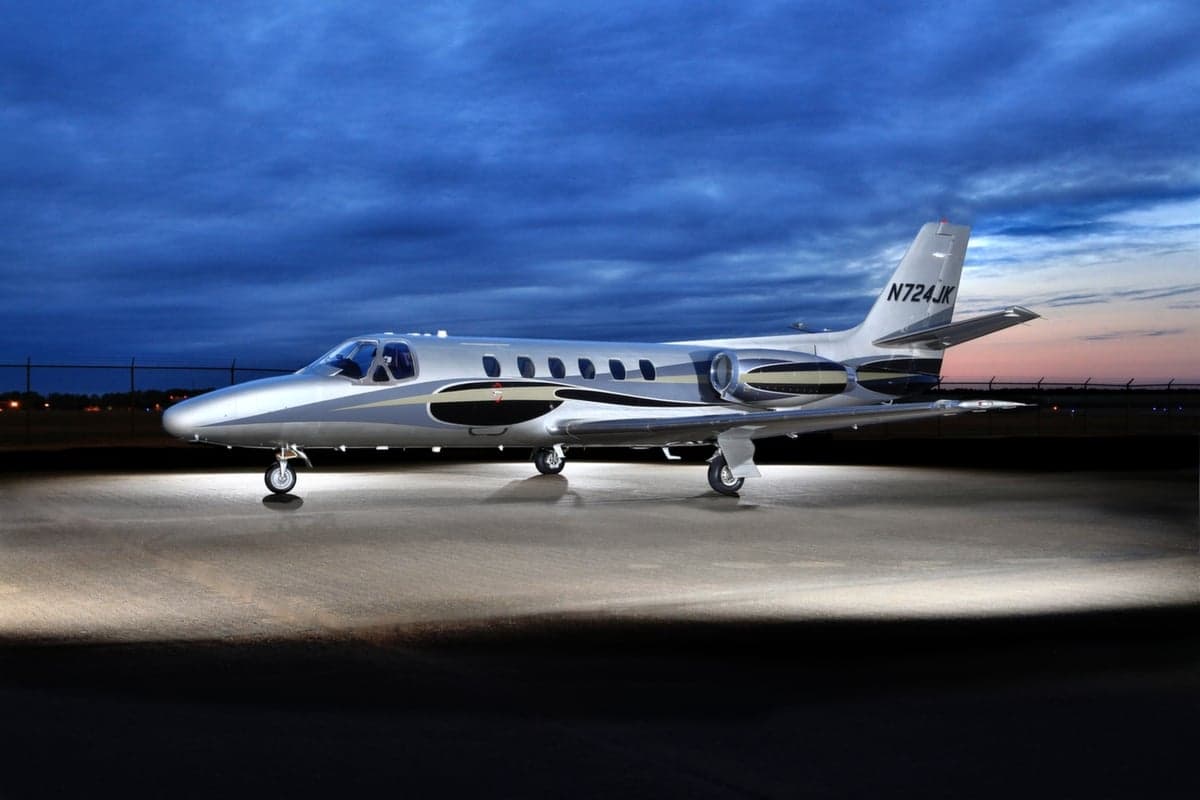 A silver Cessna Citation CJ1+ aircraft with registration N724JK is parked on the tarmac at dusk.