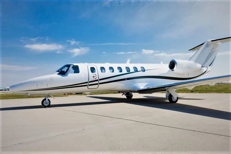A white Cessna Citation CJ3 is parked on the tarmac.