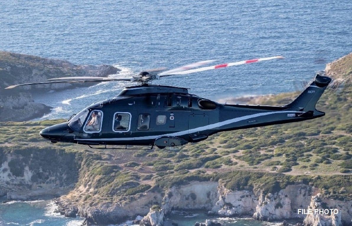 AgustaWestland AW139 helicopter in flight over a rocky coastline.
