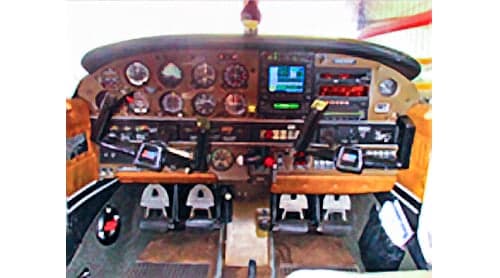 The cockpit of a light aircraft featuring a mix of analog gauges and a modern digital display.