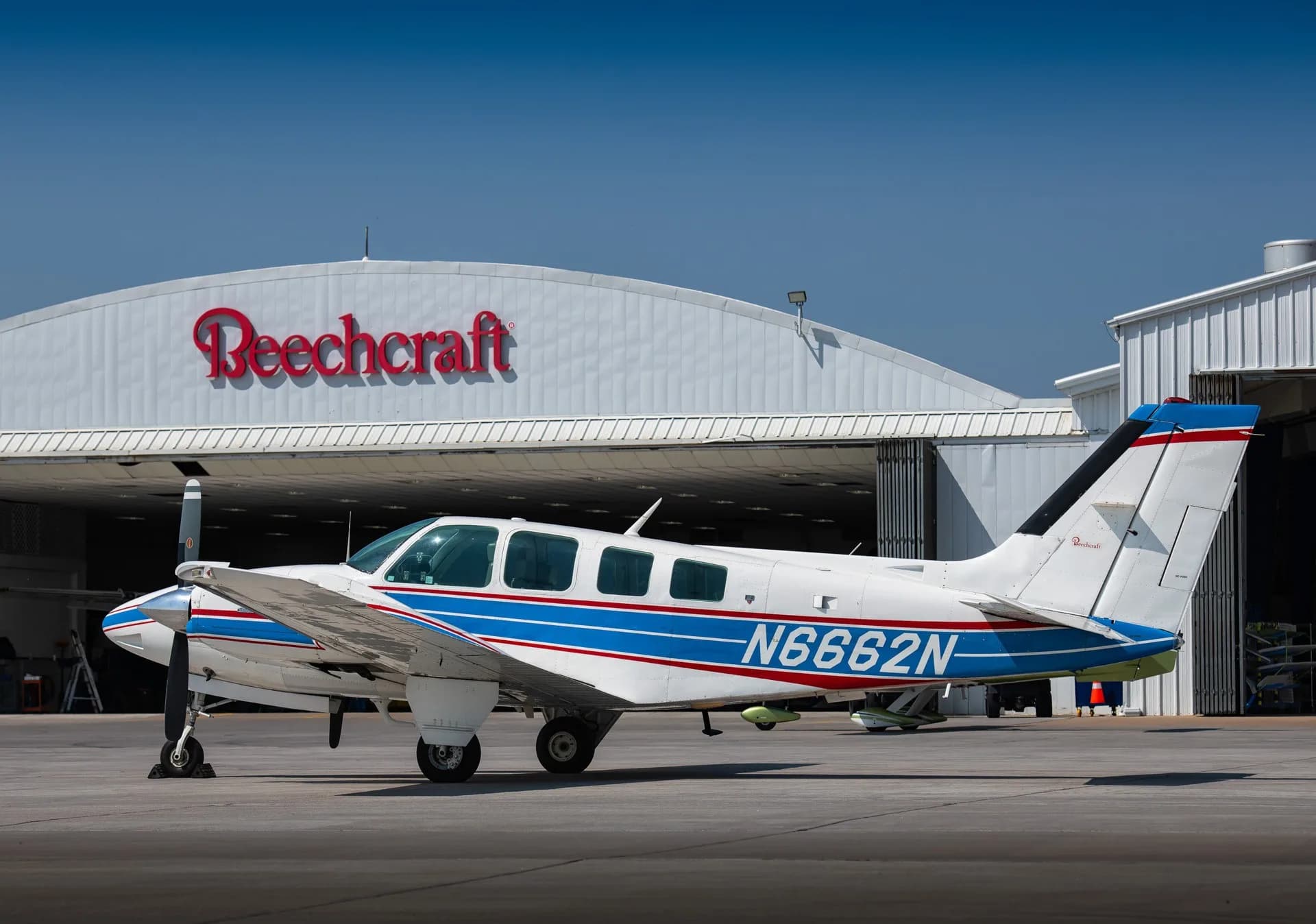 Beechcraft Bonanza N6662N parked in front of a Beechcraft hangar.