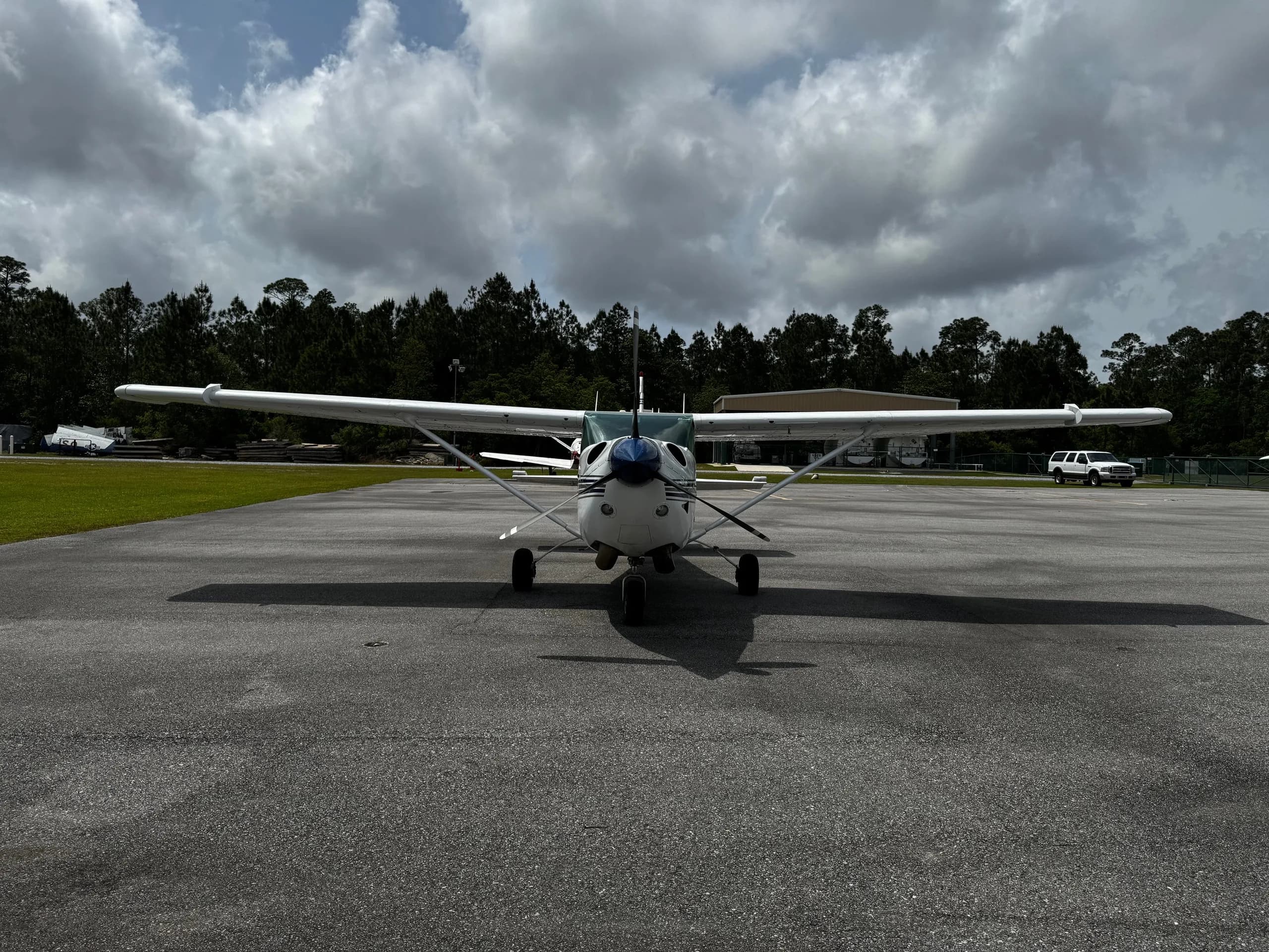 Front view of a white and blue Cessna 206 Turbo Stationair on the tarmac.
