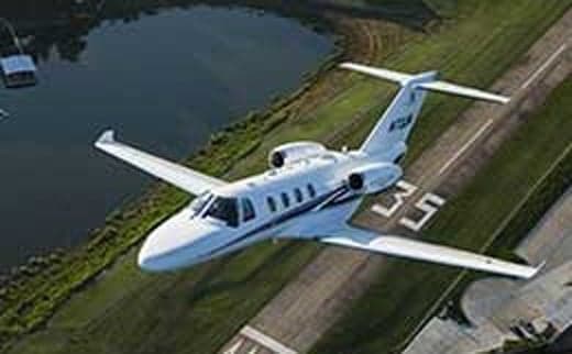 Aerial view of a white jet aircraft taking off from a runway.
