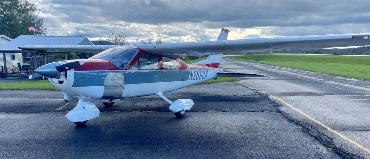 Cessna 177 Cardinal with a red and gray paint scheme parked on an airport tarmac.