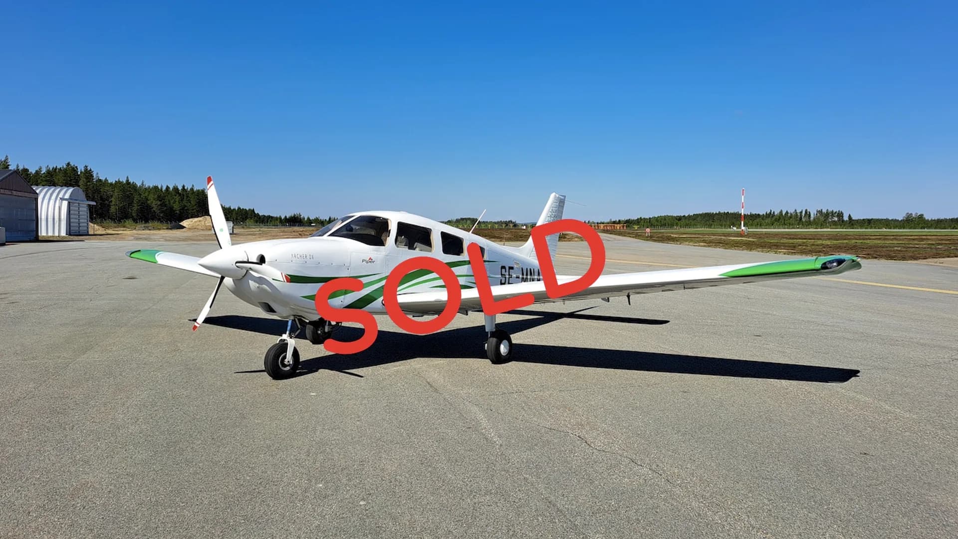 A white and green Piper Archer III aircraft with the registration SE-MNA on the tarmac, with a red SOLD overlay.