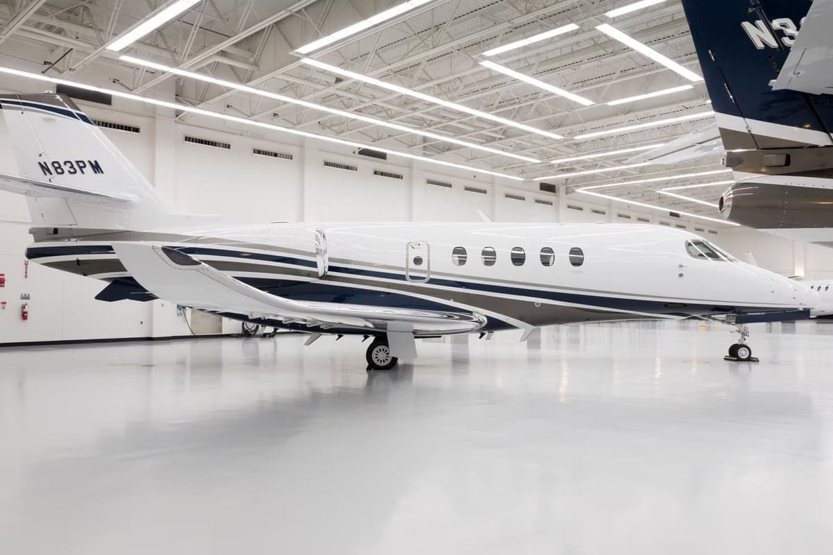 Side view of the N83PM aircraft in a hangar.