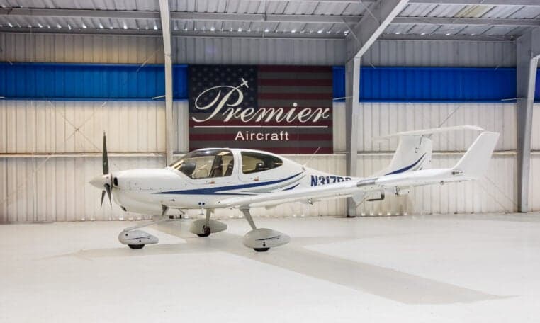 A Diamond DA40 aircraft with registration N317PS is parked in a hangar.