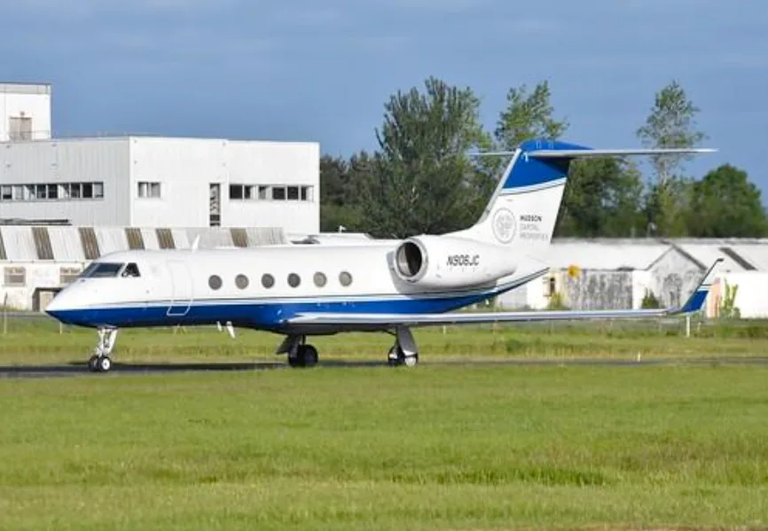 A Gulfstream G550 aircraft with blue and white livery is parked on the tarmac.