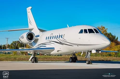 A white Dassault Falcon 900EX with registration VP-CDJ parked on the tarmac.
